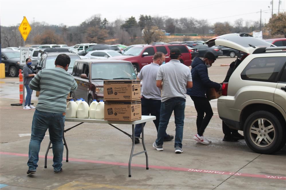  Volunteers loading food in vehicles for families