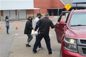 Workers opening car door to load food items