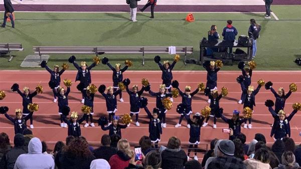 Cheerleading team performing on track at stadium