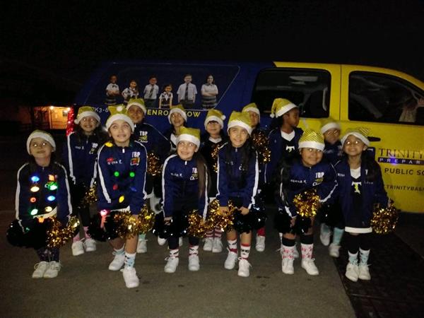 Cheerleading team posing in front of TBP vehicle