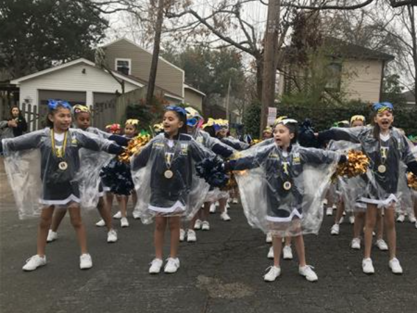 Cheerleading team performing in rain under clear ponchos